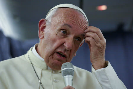 Pope Francis gestures during a news conference on board the plane during his flight back from a trip to Chile and Peru, January 22, 2018. REUTERS/Alessandro Bianchi
