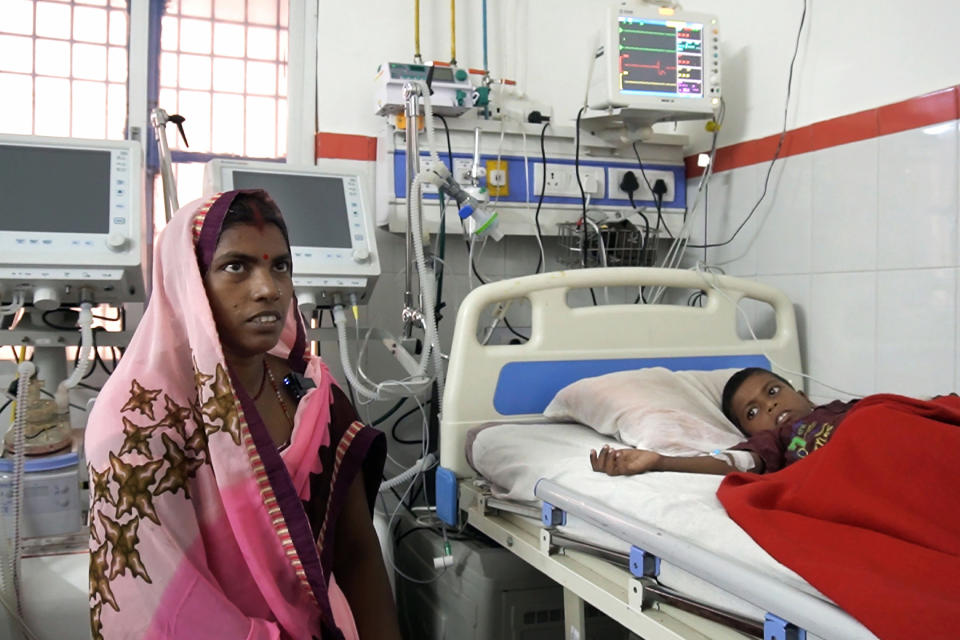 In this Sept. 13, 2019 photo, Pushpa Devi sits by the bed of her son Aryan Singh, 7, being treated for encephalitis at a hospital in Community Health Center in Chauri Chaurah in the northern Indian state of Uttar Pradesh. Cases of encephalitis, or inflammation of the brain, in Uttar Pradesh, India's most populated state with millions of rural poor, have dropped sharply. Doctors and state government officials credit a new network of rural clinics and a massive immunization and cleanliness drive in seven districts with the highest caseloads of the disease that's often deadly. An independent physician says there's no way to independently verify the government's claims, but that a decline is visible. (AP Photo/Usman Ahmad)