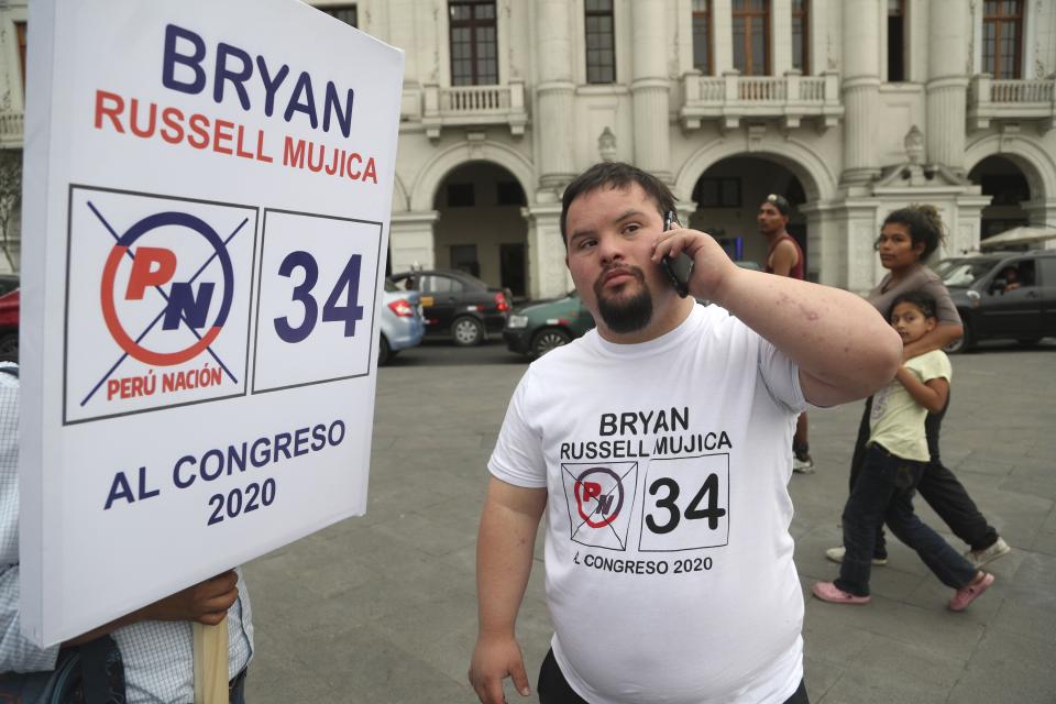 In this Dec. 13, 2019 photo, Bryan Russell takes a call as he campaigns for Congress in Lima, Peru. Russell is the first person with Down syndrome to run for public office, according to the Global Down Syndrome Foundation. (AP Photo/Martin Mejia)