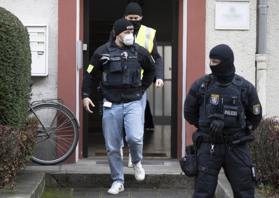 Police officers walk in front of a searched property in Frankfurt during a raid against so-called 'Reich citizens' in Frankfurt, Germany, Wednesday, Dec. 7, 2022. Thousands of police carried out a series of raids across much of Germany on Wednesday against suspected far-right extremists who allegedly sought to overthrow the state by force. Federal prosecutors said some 3,000 officers conducted searches at 130 sites in 11 of Germany's 16 states against adherents of the so-called Reich Citizens movement. Some members of the grouping reject Germany's postwar constitution and have called for the overthrow of the government. (Boris Roessler/dpa via AP)