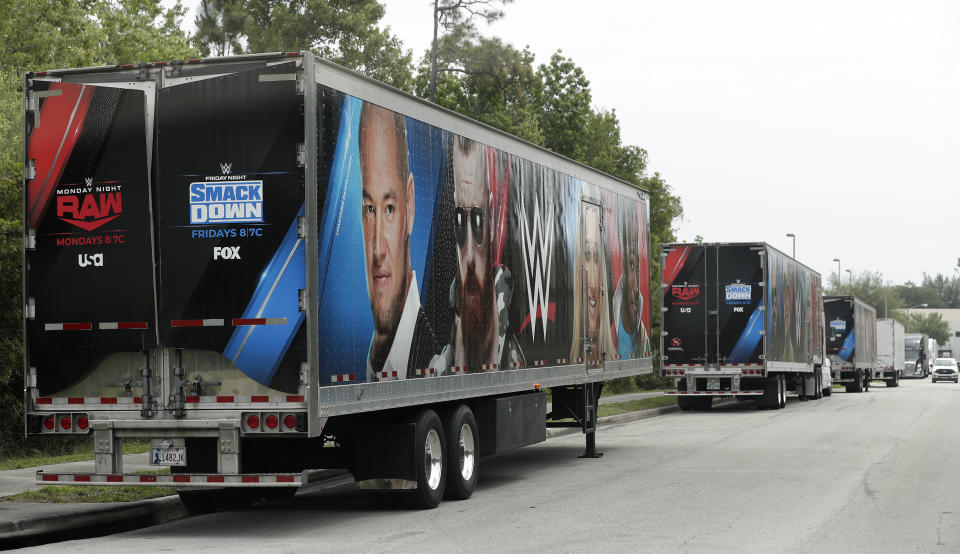 Equipment trailers are lined up at the entrance road to the WWE Performance Center Tuesday, April 14, 2020, in Orlando, Fla. Florida’s top emergency official last week amended Gov. Ron DeSantis’ stay-at-home order to include employees at the professional sports and media production with a national audience, if the location is closed to the public. (AP Photo/John Raoux)