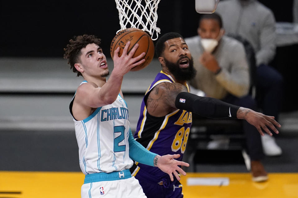 Charlotte Hornets guard LaMelo Ball, left, scores past Los Angeles Lakers forward Markieff Morris during the first half of an NBA basketball game Thursday, March 18, 2021, in Los Angeles. (AP Photo/Marcio Jose Sanchez)