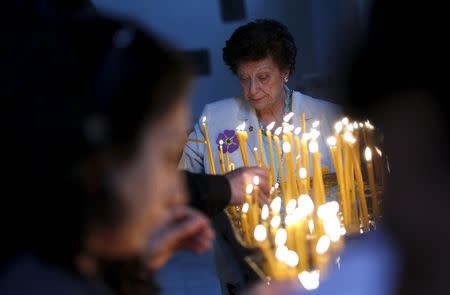 People light candles in memory of the victims of mass killings of Armenians by Ottoman Turks at the main cathedral in Echmiadzin, April 23, 2015. REUTERS/David Mdzinarishvili