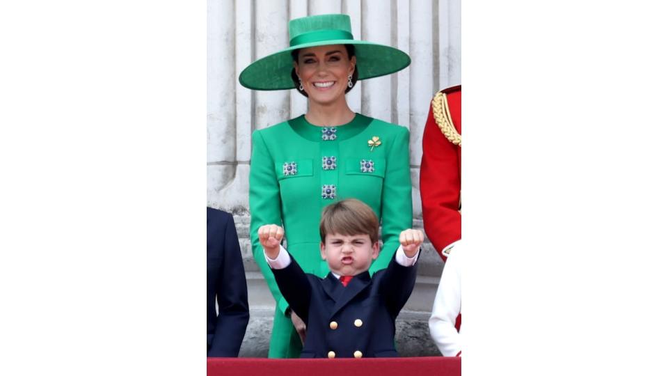 Prince Louis pretending to ride a motorcycle in front of Kate Middleton