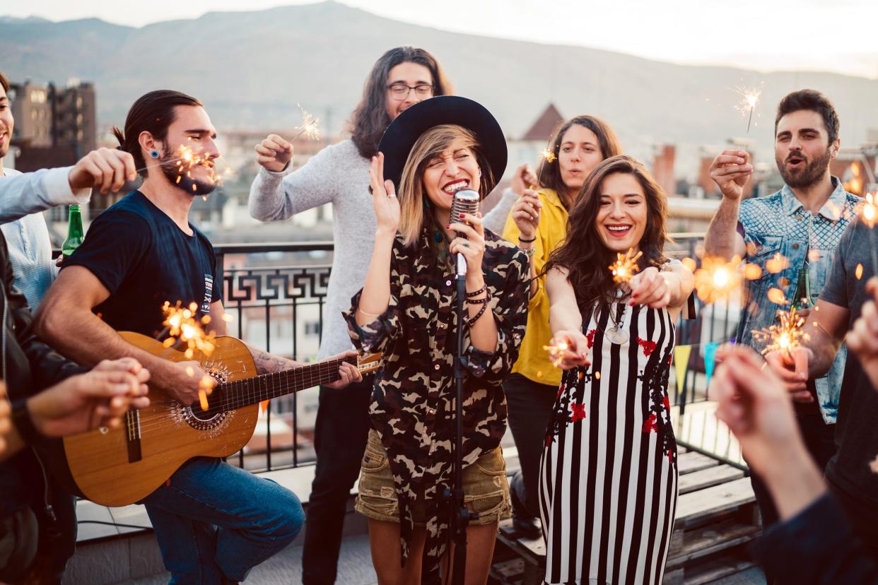 Friends having a party on a rooftop with a singer