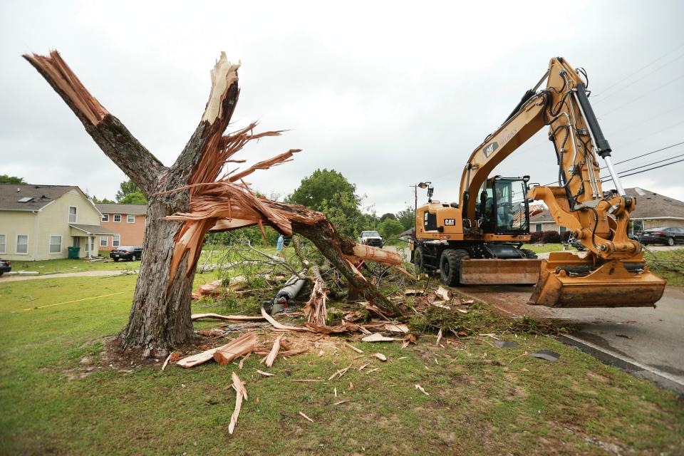 A Tupelo Public Works employee works to clear out more debris and tree limbs on Monday, May 3, 2021 after a tornado hit the area late Sunday night in Tupelo, Miss. (Adam Robison/The Northeast Mississippi Daily Journal via AP)