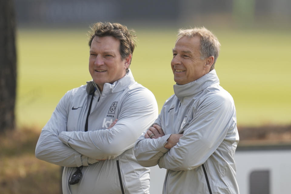 South Korea's new national team head coach Jurgen Klinsmann, right, and coach Herzog Andreas, left, watch players warm up during a training session at the National Football Center in Paju, South Korea, Monday, March 20, 2023. The team will have international friendly soccer matches with Colombia on March 24 and Uruguay on March 28. (AP Photo/Lee Jin-man)