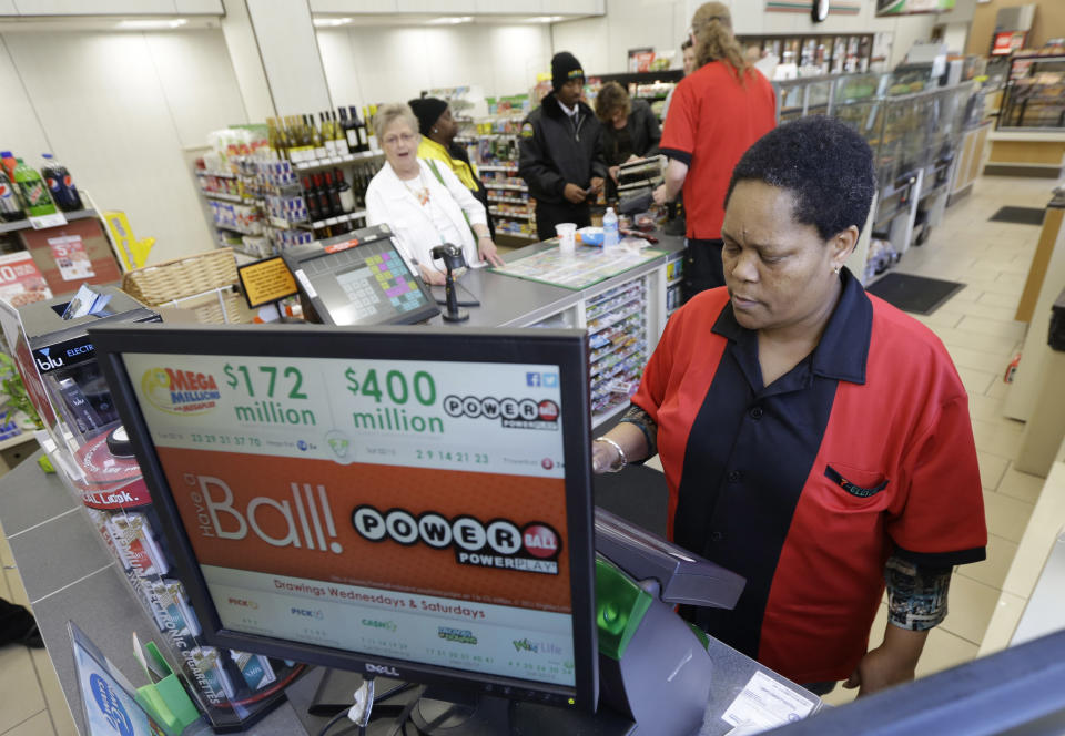 Convenience store employee, Velda Venable, of Richmond, operates a lottery machine in Richmond, Va., Wednesday, Feb. 19, 2014. The estimated Powerball lottery jackpot is $400 million. (AP Photo/Steve Helber)