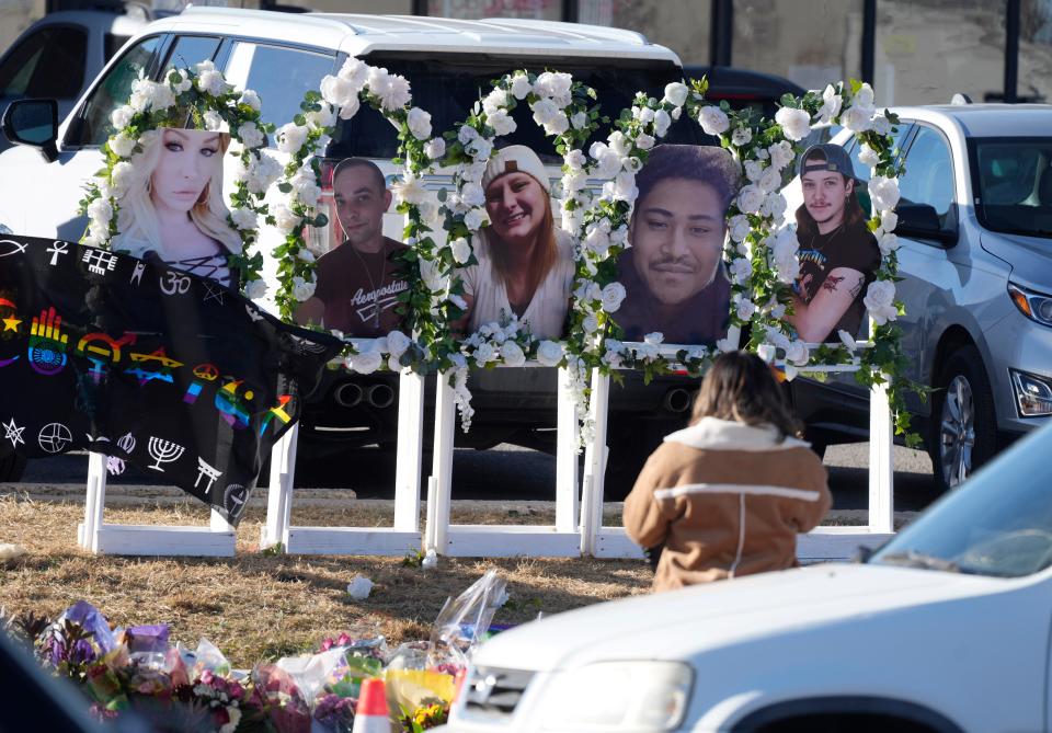 A person pauses to pay respects as portraits of the victims of a mass shooting at a gay nightclub are displayed at a makeshift memorial near Club Q in Colorado Springs, Colorado