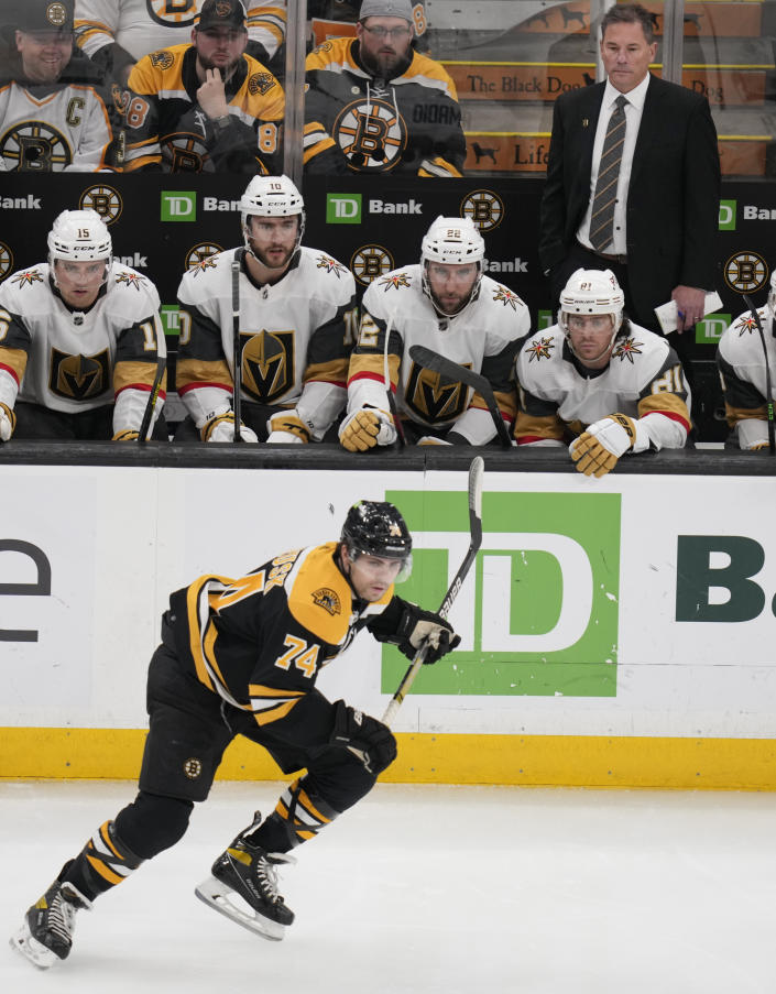 Vegas Golden Knights head coach Bruce Cassidy watches as Boston Bruins left wing Jake DeBrusk (74) skates past during the first period of an NHL hockey game, Monday, Dec. 5, 2022, in Boston. Cassidy was Bruins head coach from February 2017 until June 2022. (AP Photo/Charles Krupa)
