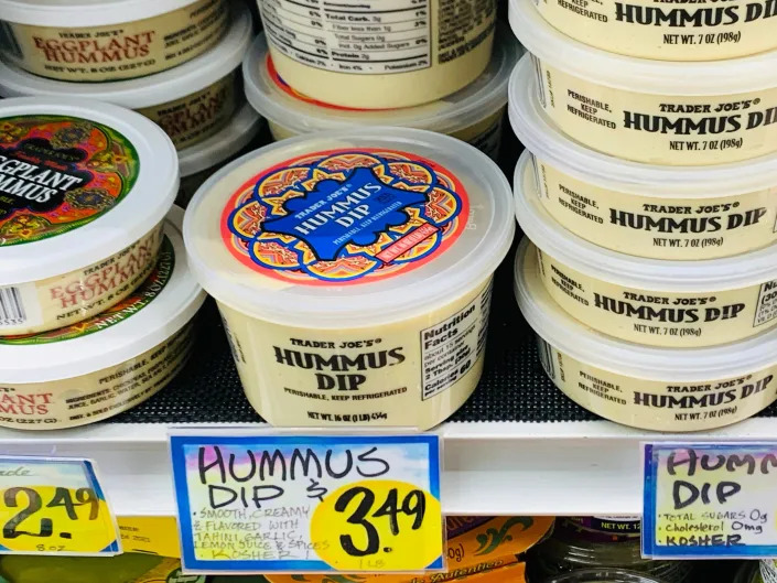 huge tubs of hummus on shelf in trader joe's