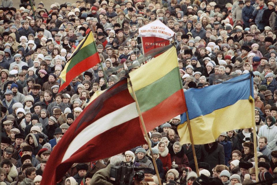 FILE - Thousands gather outside of the Parliament in a show of solidarity with Latvians who are mourning those killed by Soviet "Black Berets", an elite force of Soviet Interior Ministry troops in Vilnius, Lithuania, Jan. 26, 1991. The most vivid consequence of its standing back came in November when East Germany opened passage to West Germany and jubilant demonstrators swarmed the Berlin Wall that had blocked off the city's Soviet sector since 1961 and began hammering chunks out of it. Although Soviet forces violently put down demonstrations in Lithuania and Latvia two years later, the fall of the wall indicated that the USSR's will to imperial power was sapped. (AP Photo/Alexander Zemlianichenko, File)