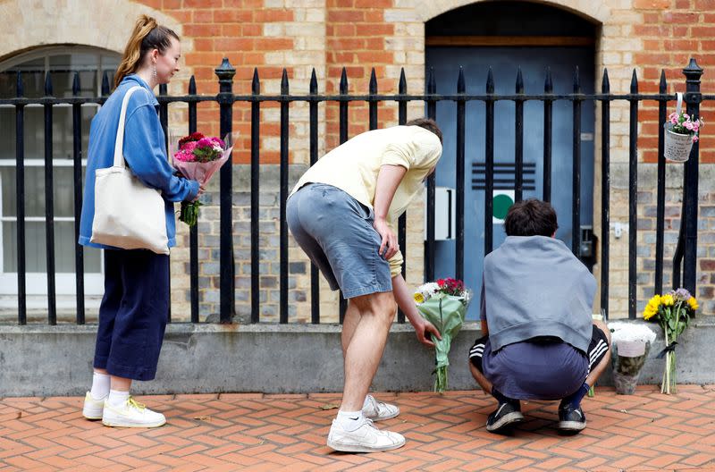 People leave flowers next to the police cordon at the scene of multiple stabbings in Reading