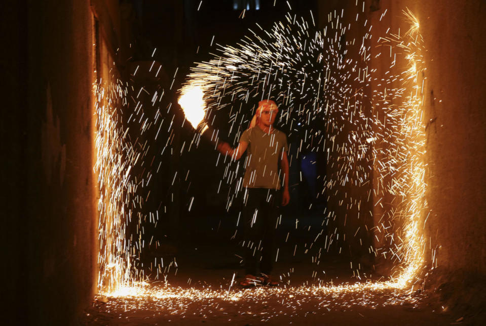 Palestinian youth plays with fireworks