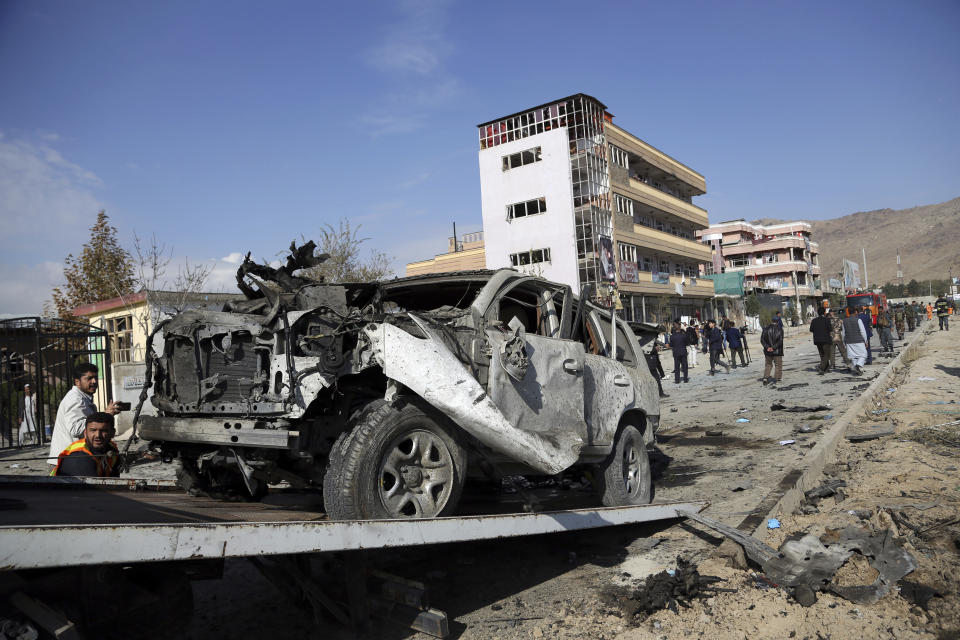 Afghan security personnel remove a damaged vehicle after a car bomb attack in Kabul, Afghanistan, Wednesday, Nov. 13, 2019. A car bomb detonated in the Afghan capital of Kabul during Wednesday's morning commute, killing several people, officials said. (AP Photo/Rahmat Gul)