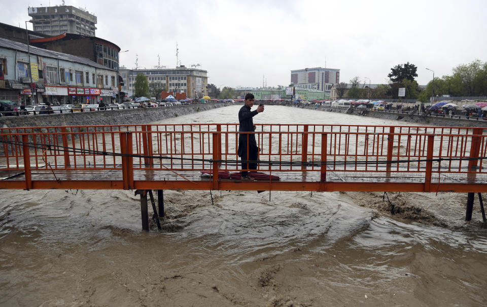 An Afghan boy take a selfie as heavy rain falls in Kabul, Afghanistan, Tuesday, April 16, 2019. Afghan officials say at least five more people have been killed and 17 are missing as a new wave of heavy rains and flooding swept across the country's western Herat province. (AP Photo/Rahmat Gul)