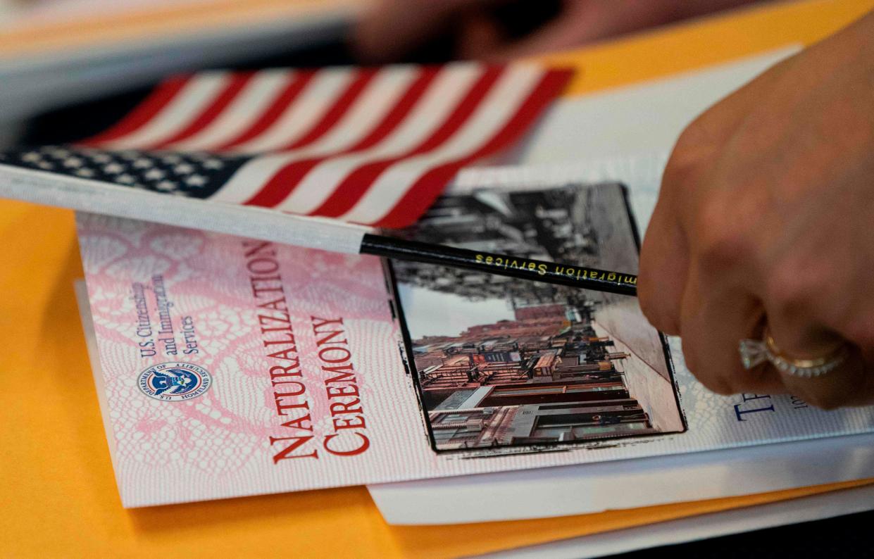 A woman, about to become a US citizen, holds a US flag and naturalization documents during a Naturalization Ceremony at the Tenement Museum June 27, 2019 in New York. The Trump Administration announced Friday that it will make changes to the citizenship test. (Photo by Don Emmert/AFP)