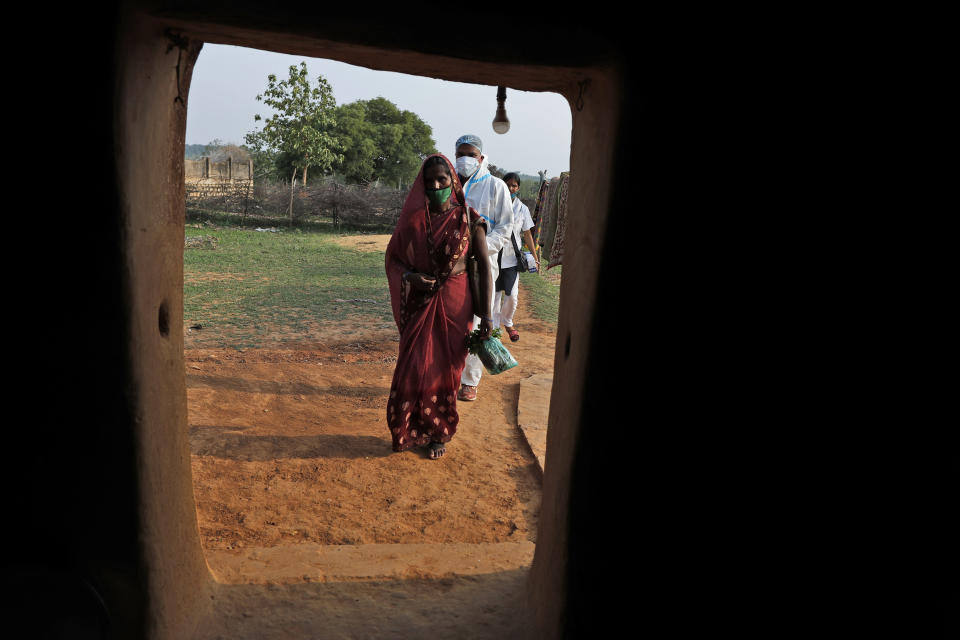 Health workers arrive at a house during a vaccination drive against COVID-19 in Jamsoti village, Uttar Pradesh state, India, on June 8, 2021. India's vaccination efforts are being undermined by widespread hesitancy and fear of the jabs, fueled by misinformation and mistrust. That's especially true in rural India, where two-thirds of the country’s nearly 1.4 billion people live. (AP Photo/Rajesh Kumar Singh)