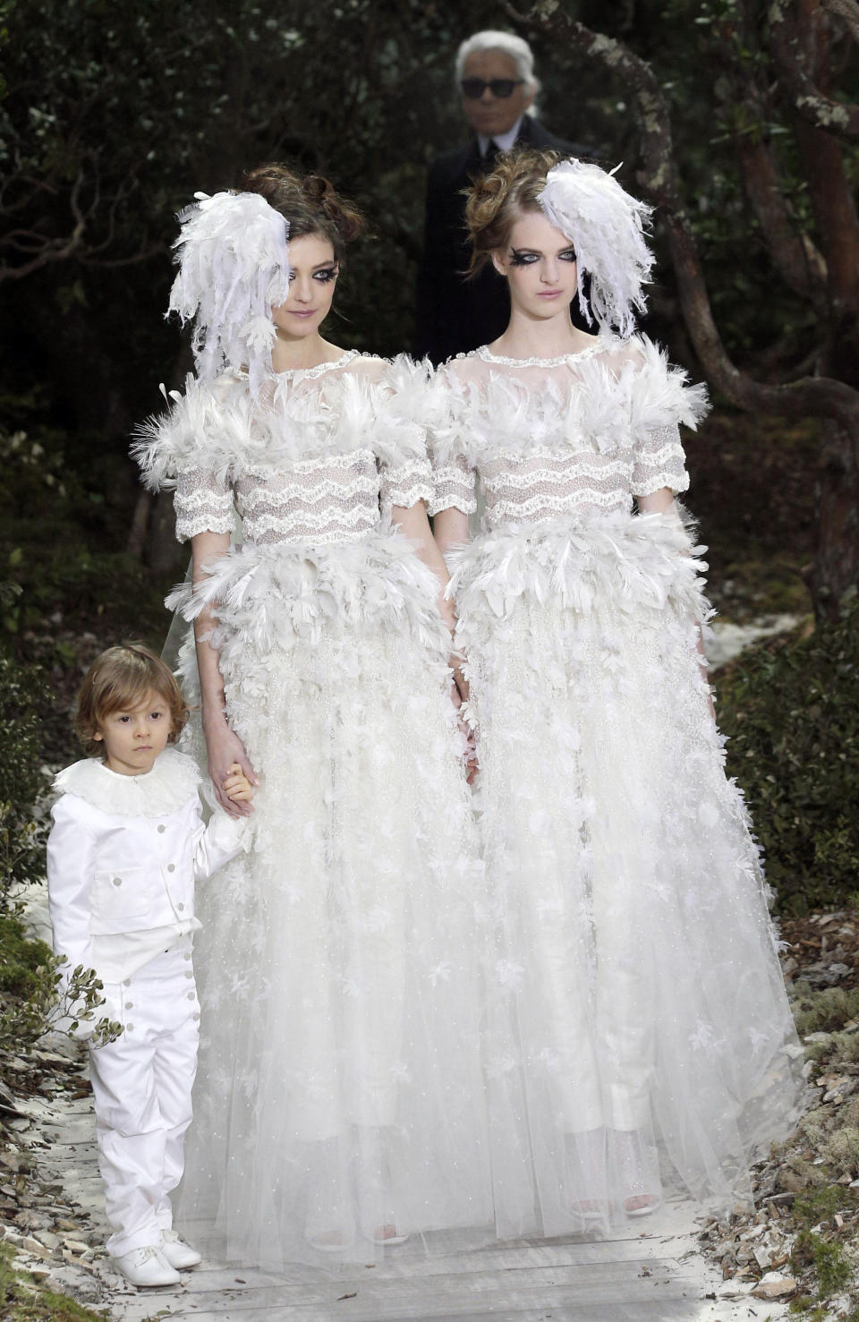 FILE - This Jan. 22, 2013 file photo shows two models wear wedding gowns by German fashion designer Karl Lagerfeld for Chanel's Spring Summer 2013 Haute Couture fashion collection, in Paris. Lagerfeld used fashion to support a controversial French gay marriage law, sending two brides together down the catwalk. (AP Photo/Christophe Ena, File)