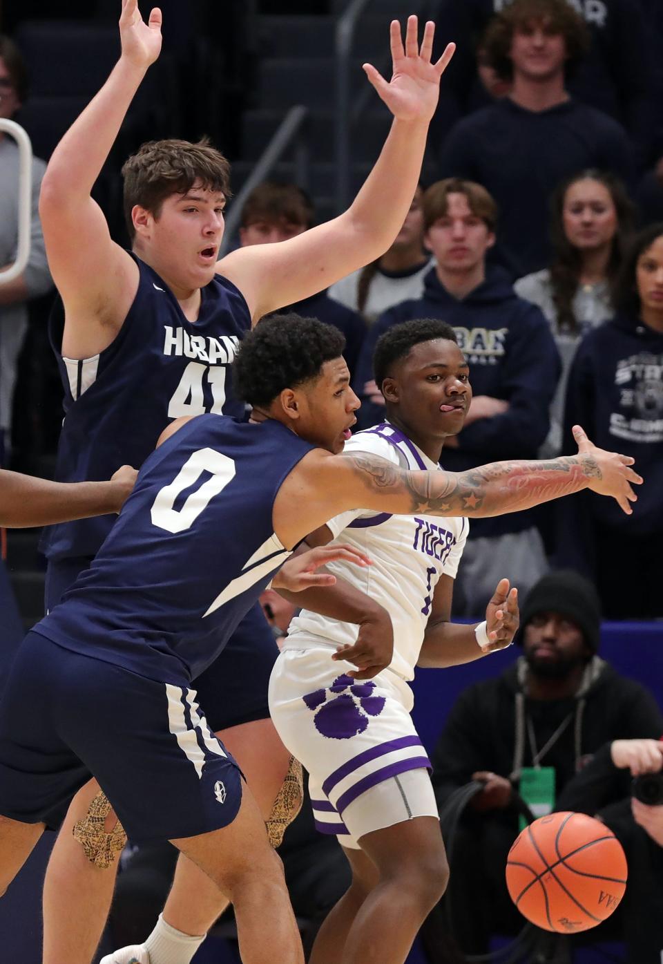 Pickerington Central guard Juwan Turner, right, makes a pass under pressure from Hoban center Sam Greer, top, and Jonas Nichols, left, during the first half of the OHSAA Division I state championship basketball game at UD Arena, Sunday, March 19, 2023, in Dayton, Ohio.