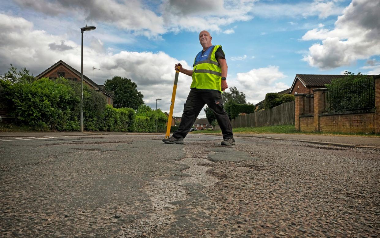 Mark Morrell, also known as Mr Pothole, with potholes in Springfield Way, Brackley