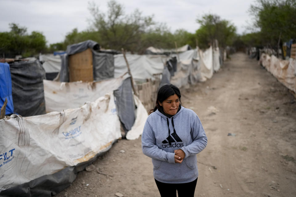 Paola Aguirre afuera de su casa en Salta, Argentina, el miércoles 4 de octubre de 2023. Aguirre, que vive en una casita levantada con maderas cerca de un vertedero, tiene puesta su esperanza en el candidato presidencial Javier Milei. (AP Foto/Natacha Pisarenko)