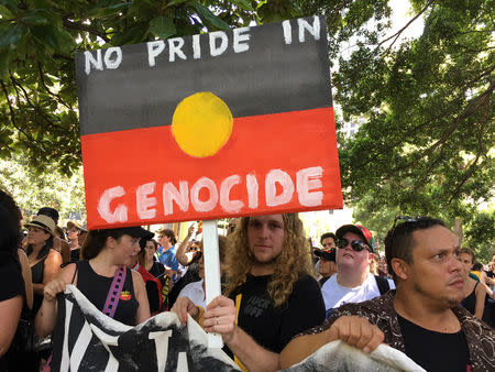 A man holds up a sign in the colours of the Australian Aboriginal flag during a demonstration on Australia Day in Sydney, January 26, 2019. REUTERS/Stefica Nicol Bikes