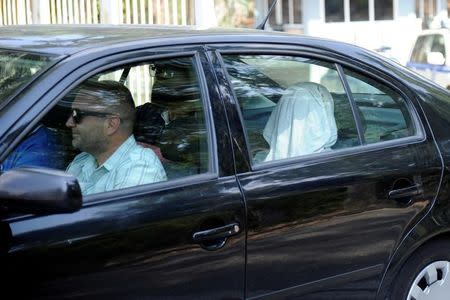 One of the eight Turkish soldiers, who fled to Greece in a helicopter and requested political asylum after a failed military coup against the government, is seen in a police car with his face covered, after his interview for asylum request at the Asylum Service in Athens, Greece, August 22, 2016. REUTERS/Michalis Karagiannis