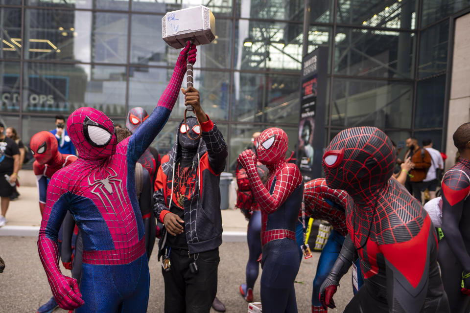 FILE - Attendees dressed as Spider-Man gather during New York Comic Con at the Jacob K. Javits Convention Center on Saturday, Oct. 9, 2021, in New York. After spending one weekend in second place, “Spider-Man: No Way Home” proved it still had some fight left. Sony's superhero juggernaut swung back to first place in its sixth weekend in theaters and became the sixth highest grossing film of all time, globally, according to studio estimates on Sunday, Jan. 23, 2022. (Photo by Charles Sykes/Invision/AP, File)