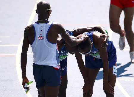 2016 Rio Olympics - Athletics - Preliminary - Men's 5000m Round 1 - Olympic Stadium - Rio de Janeiro, Brazil - 17/08/2016. Mo Farah (GBR) of Britain consoles Hassan Mead (USA) of USA REUTERS/David Gray