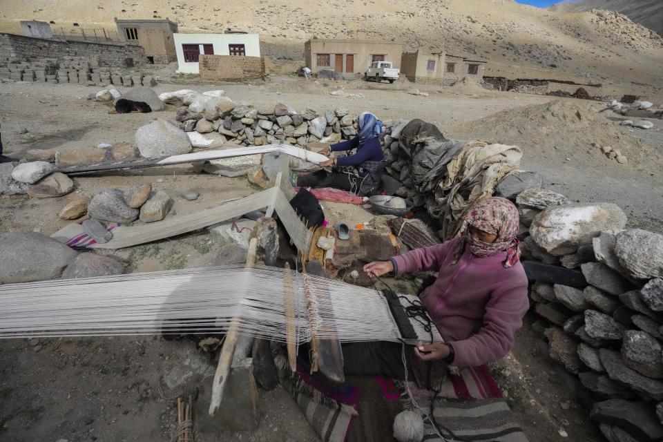 Nomad women weave a carpet in remote Kharnak village in the cold desert region of Ladakh, India, Saturday, Sept. 17, 2022. Thousands of Ladakh nomads known for their unique lifestyle in one of the most hostile landscapes in the world have been at the heart of changes caused by global warming, compounded by border conflict and shrinking grazing land. (AP Photo/Mukhtar Khan)