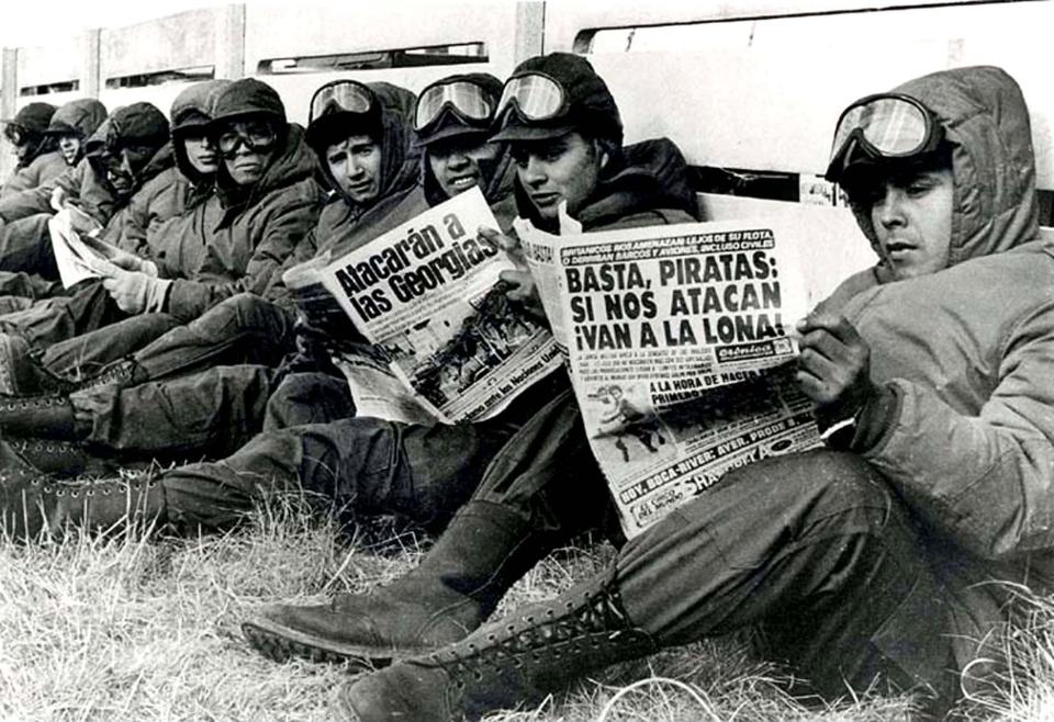 Argentinian army soldiers read newspapers in Port Stanley, during the conflict. Picture: Corbis Images.