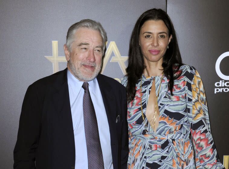 Robert De Niro and daughter Drena De Niro pose together in formal attire.