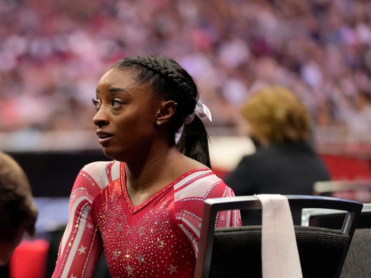 Simone Biles sits down after competing.