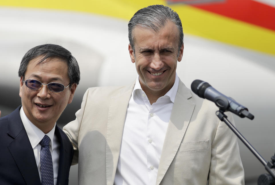 Chinese Ambassador Li Baorong, left, and Tareck El Aissami, Venezuela's minister of industry and national production, arrive to talk to reporters at the Simon Bolivar International Airport in Maiquetia, near Caracas, Venezuela, Friday, March 29, 2019. Aid was unloaded from a Chinese plane in what Venezuelan officials said would be the first delivery of many from China, an ally of the government of President Nicolas Maduro. (AP Photo/Natacha Pisarenko)