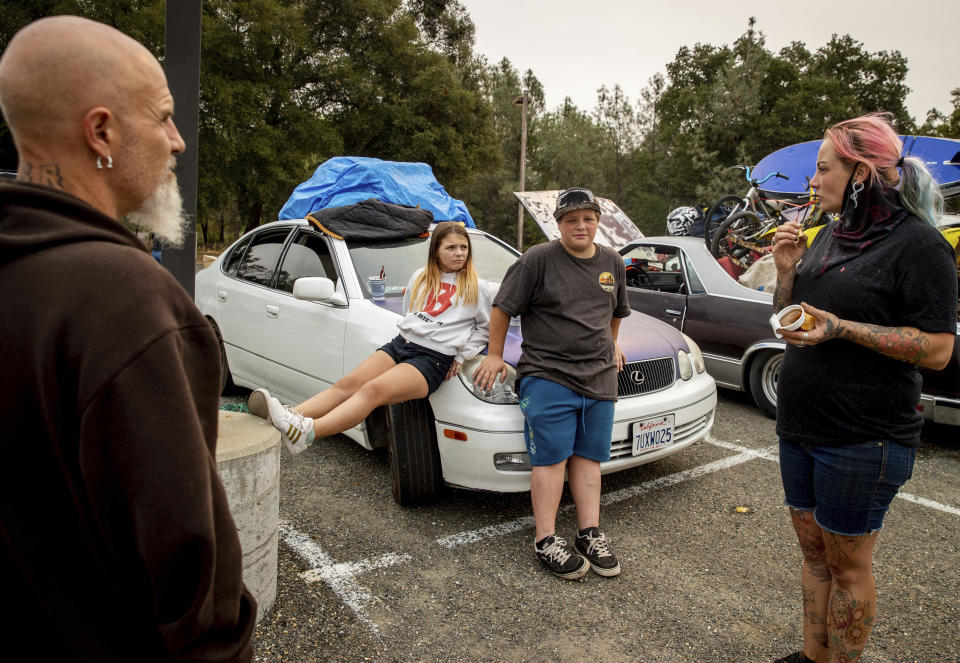 James Byers, Cali Byers, Quentin Popeyus-Byers, and Jessica Popeyus, from left, rest at the Green Valley Community Church evacuation shelter, Wednesday, Aug. 18, 2021, in Placerville, Calif., after fleeing the Caldor Fire. (AP Photo/Ethan Swope)