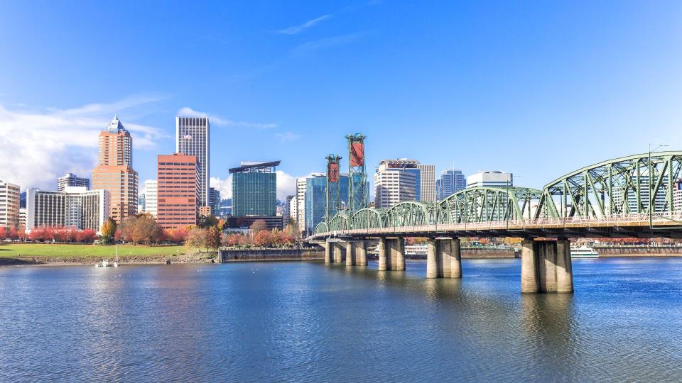 steel bridge over water with cityscape and skyline in portland.