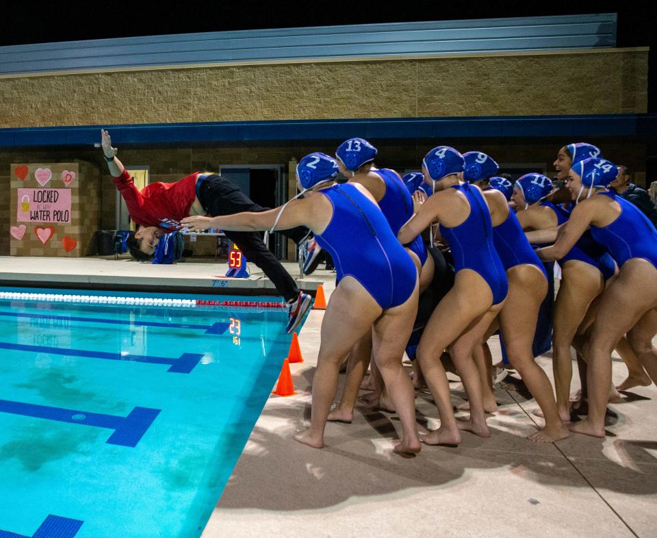 Indio players shove Indio head coach Marcos Perez into the pool as he does a front flip to celebrate winning their CIF-SS Division 6 semifinal game in Indio, Calif., Wednesday, Feb. 14, 2024.