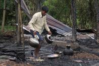 A villager salvages utensils from a burnt house after the area was set on fire in ethnic violence at Khagrabari village, in the northeastern Indian state of Assam, Saturday, May 3 2014. Police in India arrested 22 people after separatist rebels went on a rampage, burning homes and killing dozens of Muslims in the worst outbreak of ethnic violence in the remote northeastern region in two years, officials said Saturday. (AP Photo/Anupam Nath)