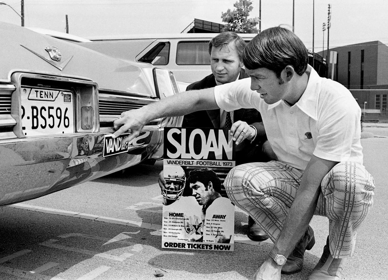 Vanderbilt head football coach Steve Sloan, right, applies a new “Vandy Football 73” bumper sticker to his own automobile with an assist from Vanderbilt Quarterback Club president Buddy Stack July 20, 1973. The Quarterback Club is starting a ticket campaign to boost the sale of season tickets.