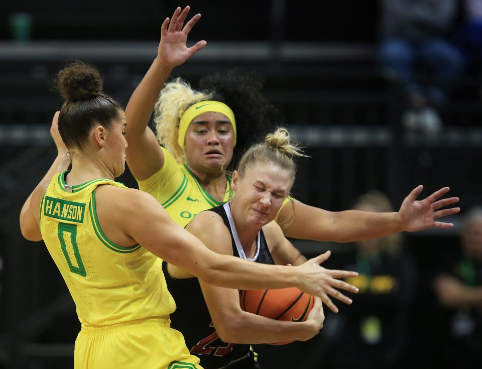 Oregon's Taya Hanson, left, and Te-Hina Paopao pressure Southern Utah's Lexi Jensen during the second half at Matthew Knight Arena Nov 21, 2022.