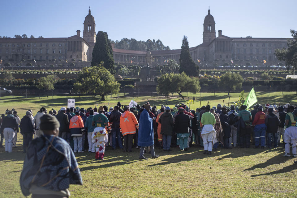 Striking miners protest for higher wages at the Union Buildings, background, in Pretoria, South Africa, Tuesday, May 24, 2022 as German Chancellor Olaf Scholz meets with South African President Cyril Ramaphosa on a one-day visit to the country. (AP Photo)