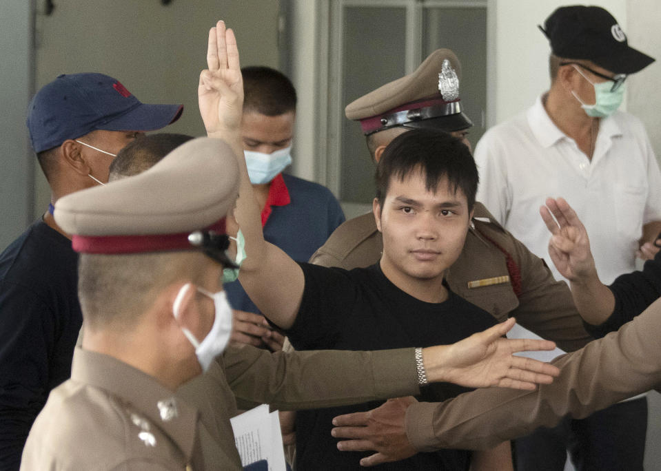 FILE - In this Aug, 26, 2020, file photo, a student protest leader Tattep Ruangprapaikitseree raises a three-finger salute, a symbol of resistance, as he leaves a police station for a court appearance in Bangkok, Thailand. Fed up with an archaic educational system and enraged by the military's efforts to keep control over their nation, a student-led campaign has shaken Thailand’s ruling establishment with the most significant campaign for political change in years. (AP Photo/Sakchai Lalit, File)