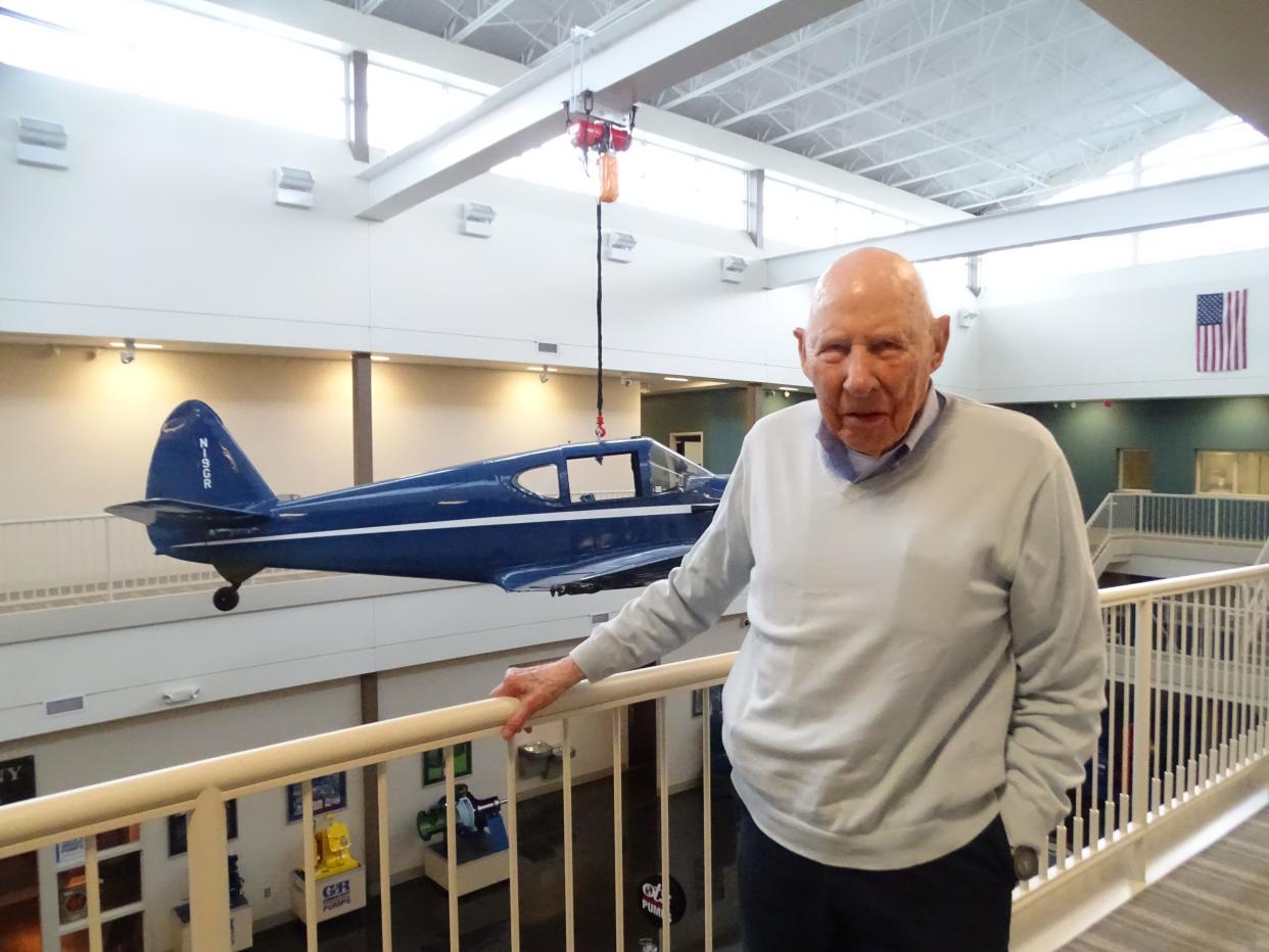 Jim Gorman stands  next to the company's first corporate plane, which hangs inside the Gorman-Rupp Co. on South Airport Road.