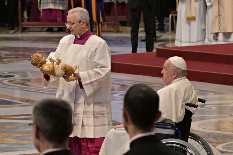 Franciso recibe una imagen del niño Jesús en la primera misa del año (Photo by Andreas SOLARO / AFP)