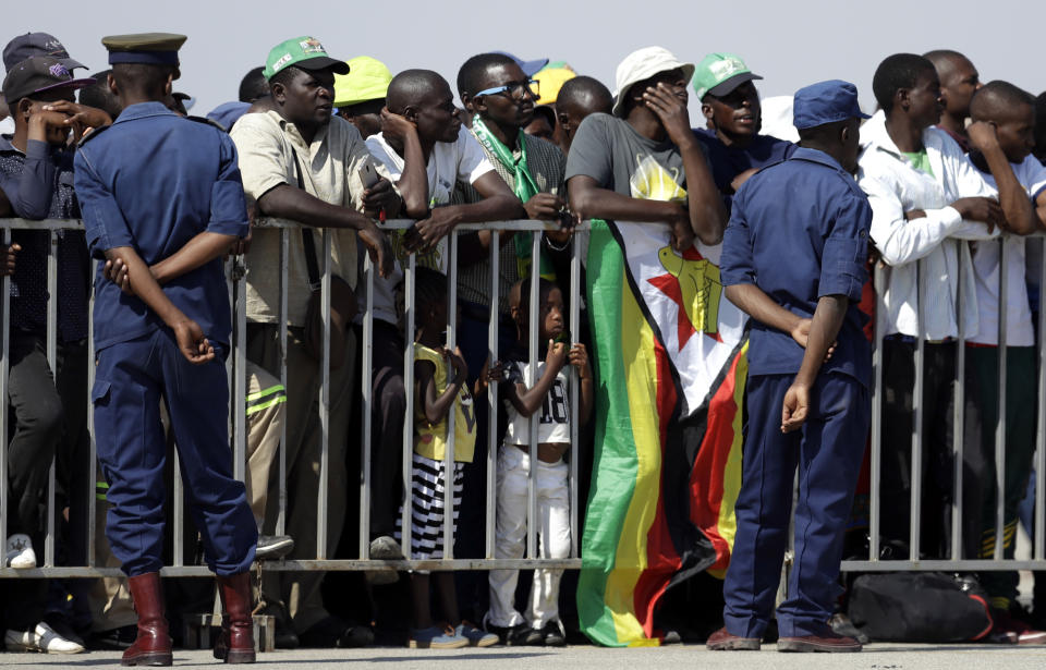 Zimbabweans await for the arrival of the body of Zimbabwe's longtime ruler Robert Mugabe from Singapore, at the Robert Gabriel Mugabe International Airport in HarareHarare, Zimbabwe, Wednesday, Sept. 11, 2019. (AP Photo/Themba Hadebe)