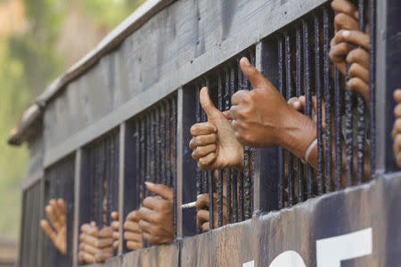 Student protesters give the thumbs up from a prison vehicle as they are transported to a court in Letpadan March 11, 2015. REUTERS/Soe Zeya Tun