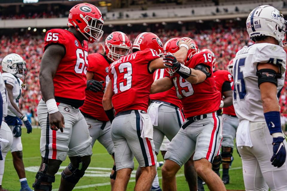 Georgia quarterback Stetson Bennett (13) reacts with teammates after running for a touchdown against Samford during the first quarter at Sanford Stadium.