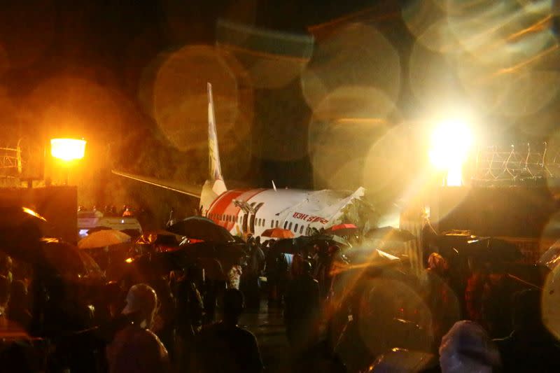 Rescue workers look for survivors after a passenger plane crashed when it overshot the runway at the Calicut International Airport in Karipur