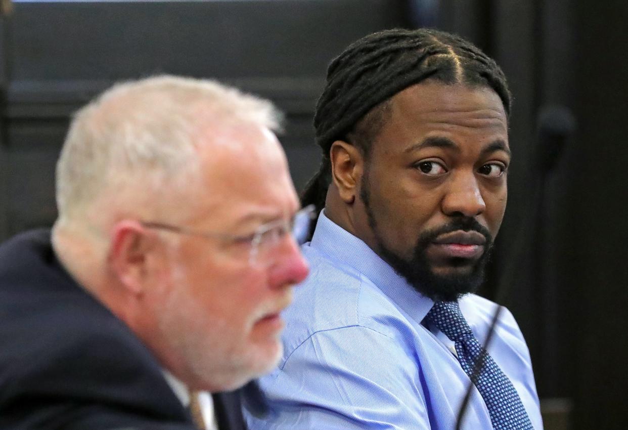 Dacarrei Kinard, right, looks on as his attorney Nathan Ray looks over a piece of evidence during his murder trial in Judge Kathryn Michael's courtroom at the Summit County Courthouse on Monday in Akron.